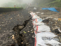 Local villagers are standing near the damaged portions of the national highway 55 due to continuous rainfall and landslides, on the route of...