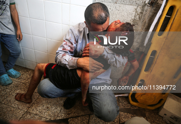 (EDITOR'S NOTE: Image depicts death) A Palestinian father is carrying the body of his son who was killed in an Israeli strike, amid the Isra...