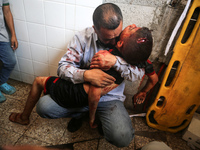 (EDITOR'S NOTE: Image depicts death) A Palestinian father is carrying the body of his son who was killed in an Israeli strike, amid the Isra...