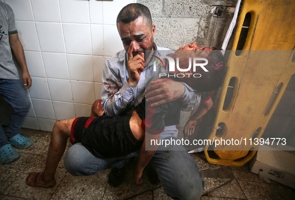 (EDITOR'S NOTE: Image depicts death) A Palestinian father is carrying the body of his son who was killed in an Israeli strike, amid the Isra...