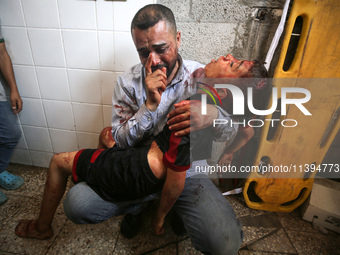 (EDITOR'S NOTE: Image depicts death) A Palestinian father is carrying the body of his son who was killed in an Israeli strike, amid the Isra...