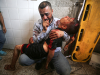 (EDITOR'S NOTE: Image depicts death) A Palestinian father is carrying the body of his son who was killed in an Israeli strike, amid the Isra...