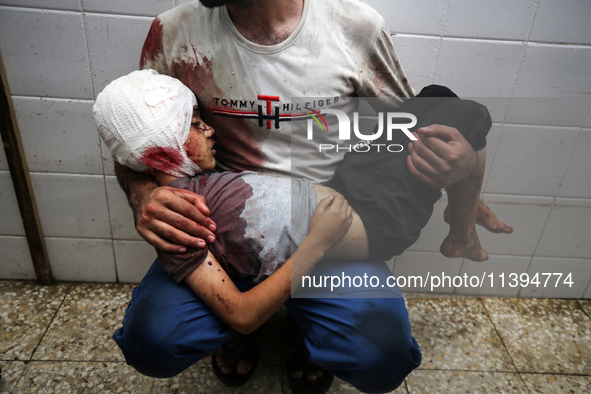 (EDITOR'S NOTE: Image depicts death) A Palestinian father is carrying the body of his son who was killed in an Israeli strike, amid the Isra...