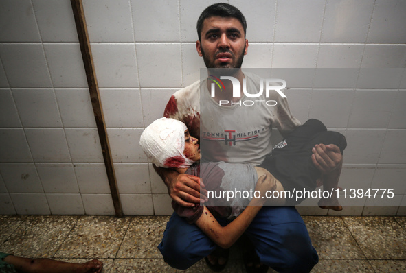 (EDITOR'S NOTE: Image depicts death) A Palestinian father is carrying the body of his son who was killed in an Israeli strike, amid the Isra...