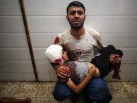 (EDITOR'S NOTE: Image depicts death) A Palestinian father is carrying the body of his son who was killed in an Israeli strike, amid the Isra...