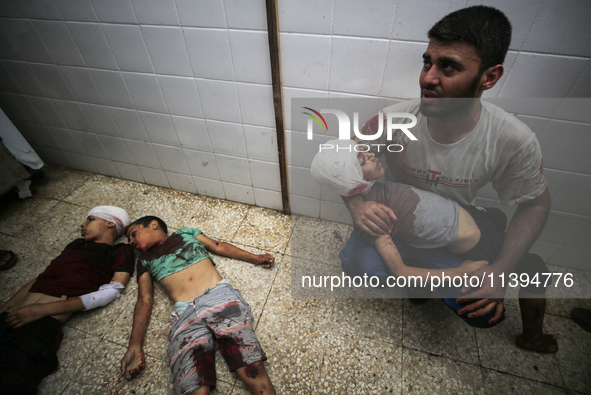 (EDITOR'S NOTE: Image depicts death) A Palestinian father is carrying the body of his son who was killed in an Israeli strike, amid the Isra...