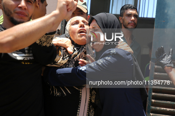 People are crying near the bodies of Palestinians killed in Israeli strikes, amid the Israel-Hamas conflict, at Al-Aqsa Martyrs Hospital in...