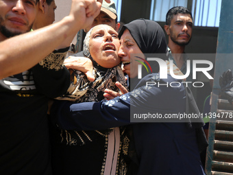 People are crying near the bodies of Palestinians killed in Israeli strikes, amid the Israel-Hamas conflict, at Al-Aqsa Martyrs Hospital in...