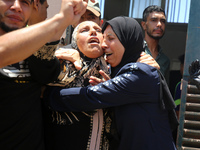 People are crying near the bodies of Palestinians killed in Israeli strikes, amid the Israel-Hamas conflict, at Al-Aqsa Martyrs Hospital in...