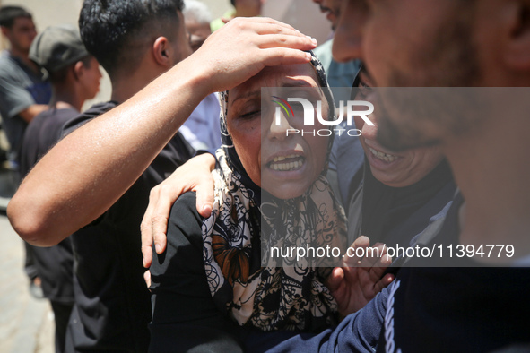 People are crying near the bodies of Palestinians killed in Israeli strikes, amid the Israel-Hamas conflict, at Al-Aqsa Martyrs Hospital in...