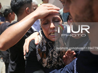 People are crying near the bodies of Palestinians killed in Israeli strikes, amid the Israel-Hamas conflict, at Al-Aqsa Martyrs Hospital in...