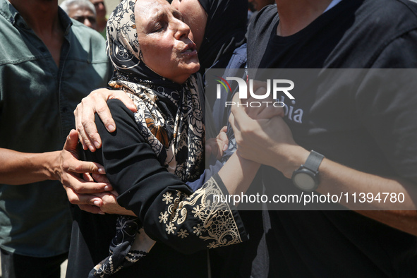 People are crying near the bodies of Palestinians killed in Israeli strikes, amid the Israel-Hamas conflict, at Al-Aqsa Martyrs Hospital in...