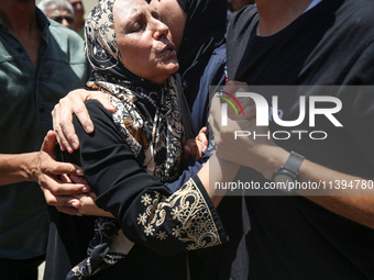 People are crying near the bodies of Palestinians killed in Israeli strikes, amid the Israel-Hamas conflict, at Al-Aqsa Martyrs Hospital in...