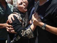 People are crying near the bodies of Palestinians killed in Israeli strikes, amid the Israel-Hamas conflict, at Al-Aqsa Martyrs Hospital in...