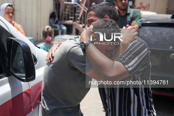 People are crying near the bodies of Palestinians killed in Israeli strikes, amid the Israel-Hamas conflict, at Al-Aqsa Martyrs Hospital in...