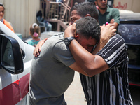 People are crying near the bodies of Palestinians killed in Israeli strikes, amid the Israel-Hamas conflict, at Al-Aqsa Martyrs Hospital in...