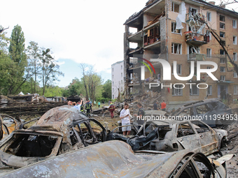 Burnt-out cars are being pictured at a five-storey apartment block in the Holosiivskyi district destroyed by the Russian missile attack in K...