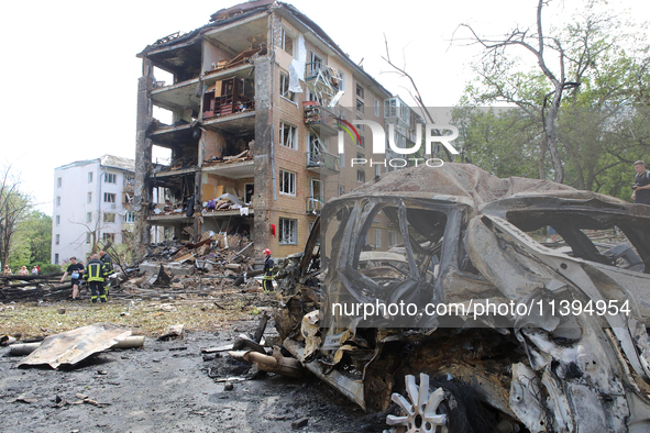 A burnt-out car is being pictured at a five-storey apartment block in the Holosiivskyi district destroyed by the Russian missile attack in K...