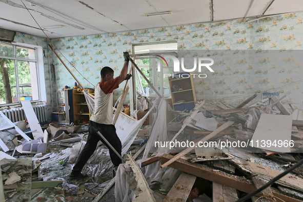 A man is removing the rubble at a kindergarten in the Holosiivskyi district after the Russian missile attack in Kyiv, Ukraine, on July 8, 20...