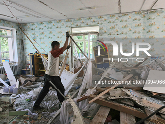 A man is removing the rubble at a kindergarten in the Holosiivskyi district after the Russian missile attack in Kyiv, Ukraine, on July 8, 20...