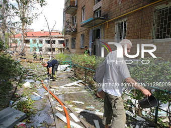 Rescuers and a man are being pictured at a five-storey apartment block in the Holosiivskyi district destroyed by the Russian missile attack...