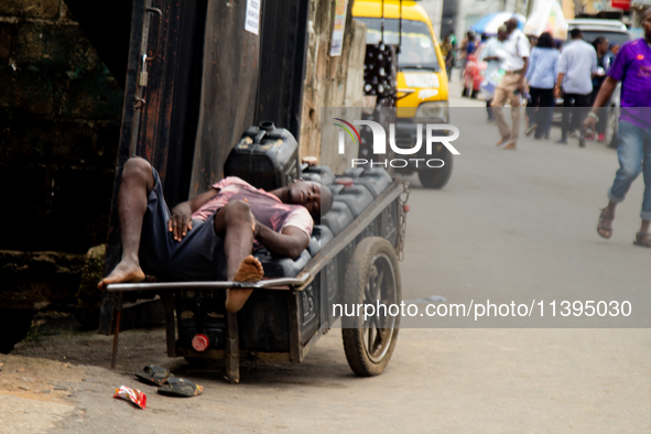 A water vendor is sleeping on his kegs of water as members of the Ministry of Environment in Lagos are embarking on a door-to-door campaign...