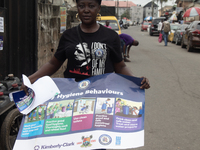 A woman is holding a poster as members of the Ministry of Environment in Lagos are embarking on a door-to-door campaign to sensitize the cit...