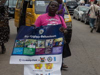 A woman is holding a poster as members of the Ministry of Environment in Lagos are embarking on a door-to-door campaign to sensitize the cit...