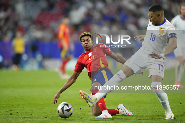 Lamine Yamal right winger of Spain and FC Barcelona and Kylian Mbappe centre-forward of France and Real Madrid compete for the ball during t...