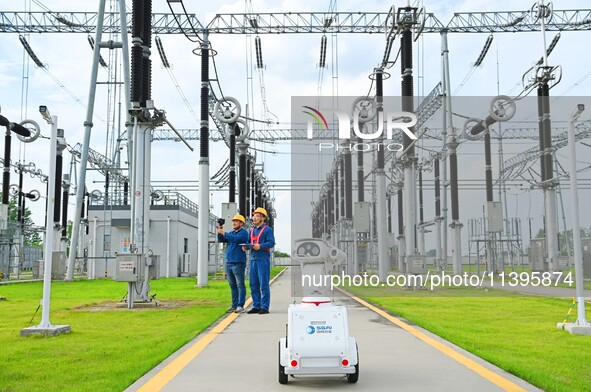 A 5G intelligent robot and operation and maintenance personnel are carrying out a special inspection of the power supply equipment in a 500-...