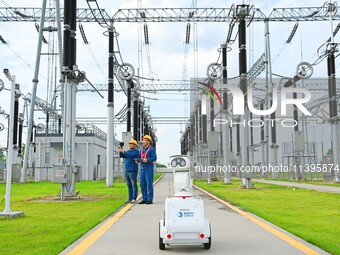 A 5G intelligent robot and operation and maintenance personnel are carrying out a special inspection of the power supply equipment in a 500-...