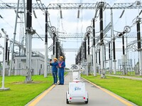 A 5G intelligent robot and operation and maintenance personnel are carrying out a special inspection of the power supply equipment in a 500-...