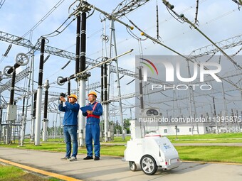 A 5G intelligent robot and operation and maintenance personnel are carrying out a special inspection of the power supply equipment in a 500-...