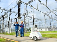 A 5G intelligent robot and operation and maintenance personnel are carrying out a special inspection of the power supply equipment in a 500-...