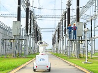 A 5G intelligent robot and operation and maintenance personnel are carrying out a special inspection of the power supply equipment in a 500-...