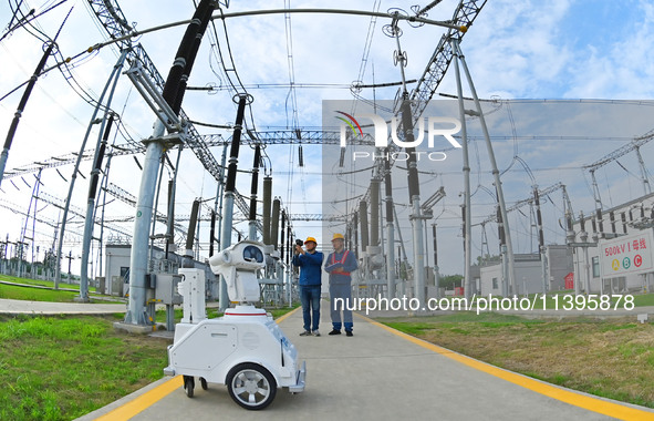 A 5G intelligent robot and operation and maintenance personnel are carrying out a special inspection of the power supply equipment in a 500-...