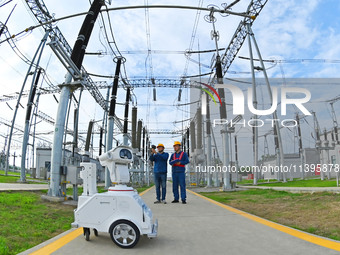 A 5G intelligent robot and operation and maintenance personnel are carrying out a special inspection of the power supply equipment in a 500-...