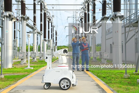 A 5G intelligent robot and operation and maintenance personnel are carrying out a special inspection of the power supply equipment in a 500-...