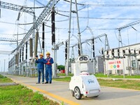 A 5G intelligent robot and operation and maintenance personnel are carrying out a special inspection of the power supply equipment in a 500-...