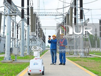 A 5G intelligent robot and operation and maintenance personnel are carrying out a special inspection of the power supply equipment in a 500-...