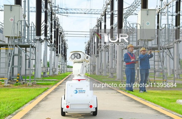 A 5G intelligent robot and operation and maintenance personnel are carrying out a special inspection of the power supply equipment in a 500-...