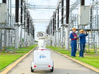 A 5G intelligent robot and operation and maintenance personnel are carrying out a special inspection of the power supply equipment in a 500-...