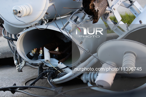 A fallen power line's distribution transformer is becoming misshapen and broken from the powerful winds of Hurricane Beryl in Houston, Texas...