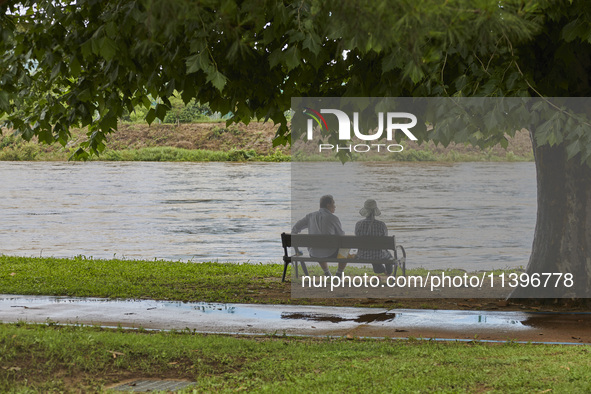 People are watching the river that is overflowing to the danger level due to the heavy rain last night at Younggang-river in Moongyeong, Sou...