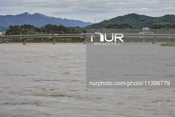 A general view of the river that is overflowing to the danger level due to the heavy rain last night at Younggang-river in Moongyeong, South...