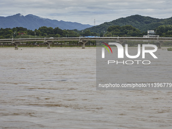 A general view of the river that is overflowing to the danger level due to the heavy rain last night at Younggang-river in Moongyeong, South...