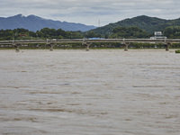 A general view of the river that is overflowing to the danger level due to the heavy rain last night at Younggang-river in Moongyeong, South...