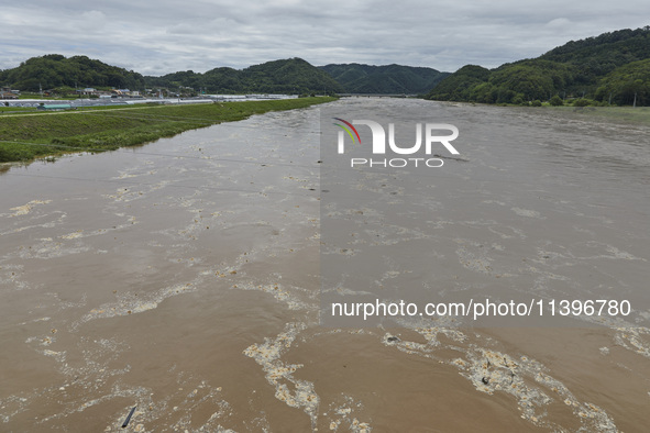 A general view of the river that is overflowing to the danger level due to the heavy rain last night at Younggang-river in Moongyeong, South...