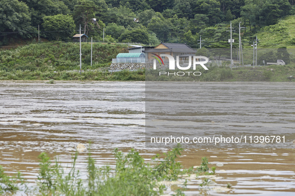 The isolated houses on the other side of the river that is overflowing to the danger level due to the heavy rain last night are being seen a...