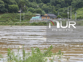 The isolated houses on the other side of the river that is overflowing to the danger level due to the heavy rain last night are being seen a...